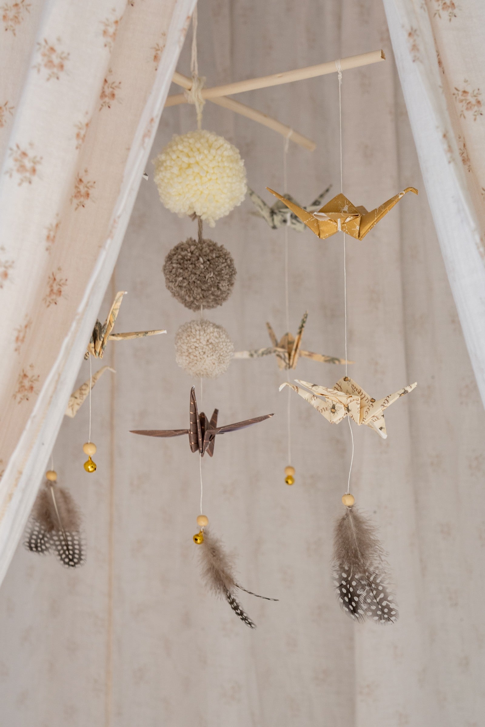 Gold and patterned origami cranes with grey feathers and tiny bells