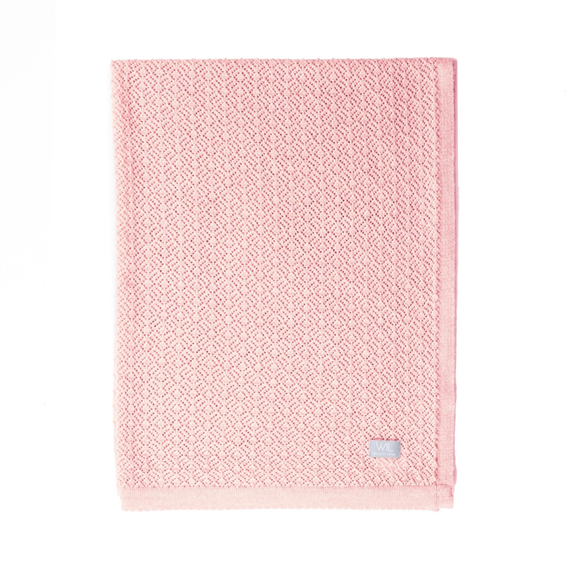 Couverture bébé en tricot rose avec motif losanges, coton doux, pliée sur fond blanc