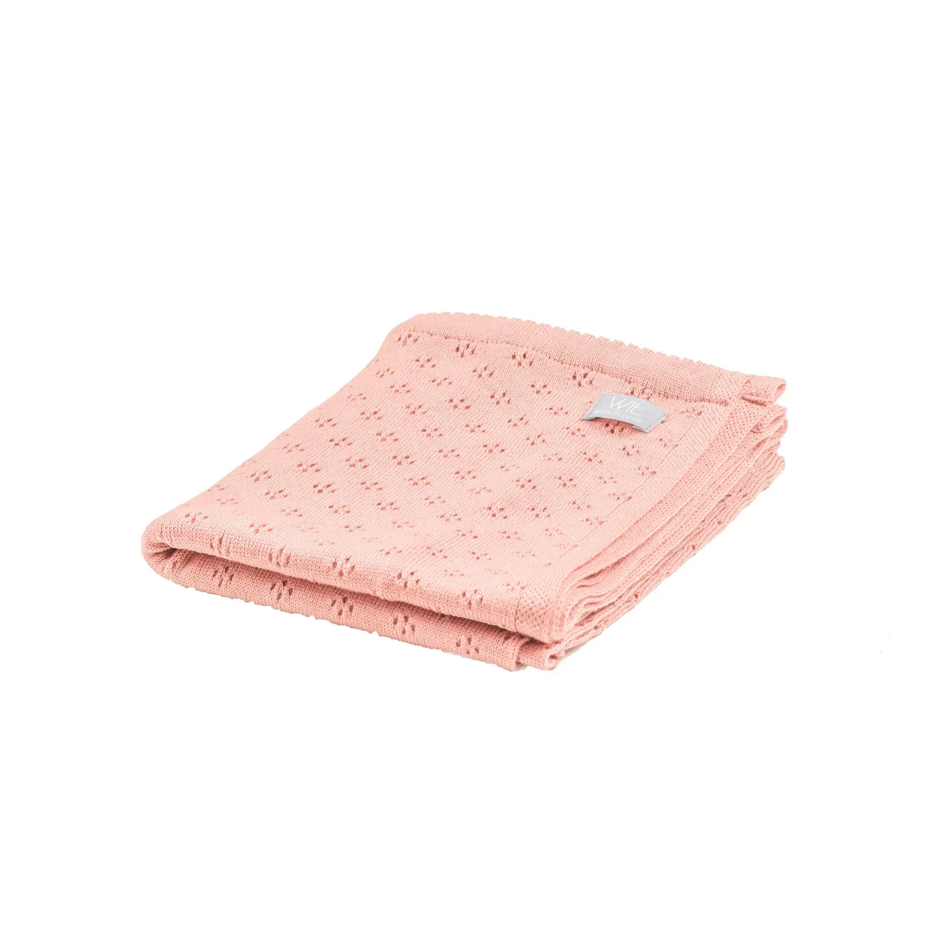 Couverture bébé en tricot rose en coton bio avec motif délicat, pliée soigneusement