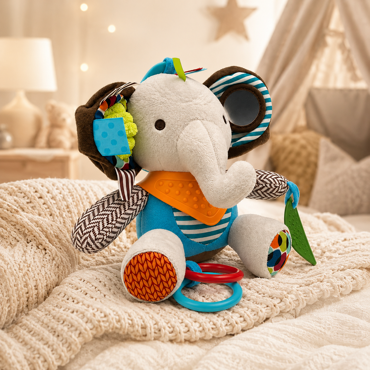 Sensory elephant activity toy displayed on soft nursery blanket with mirror, mixed fabrics and colourful tactile details