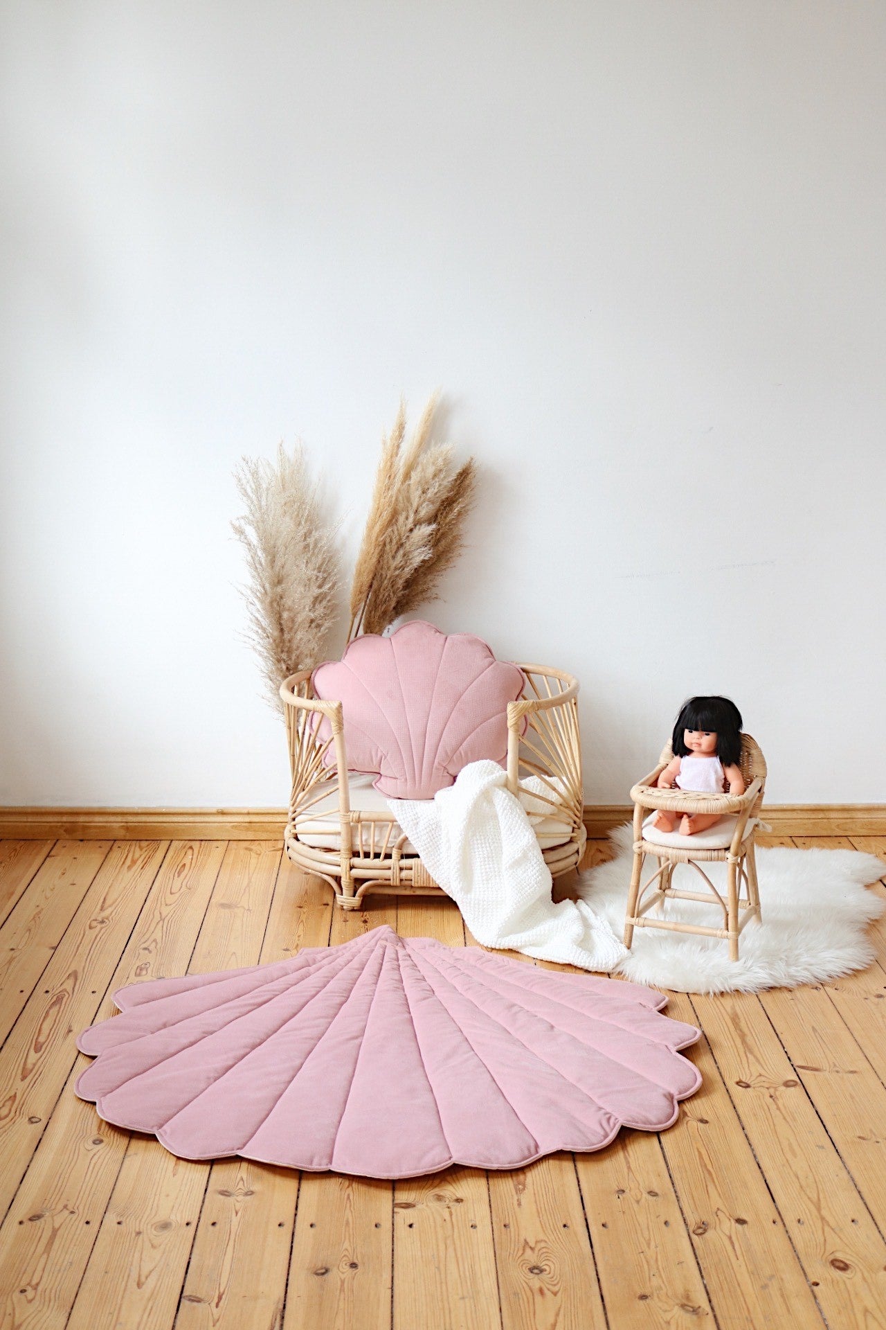 Powder pink shell playmat styled with a rattan basket, doll chair and matching shell cushion