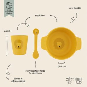 Set de vaisselle en silicone jaune avec motif lion, incluant une assiette ventouse divisée, un gobelet et une cuillère.