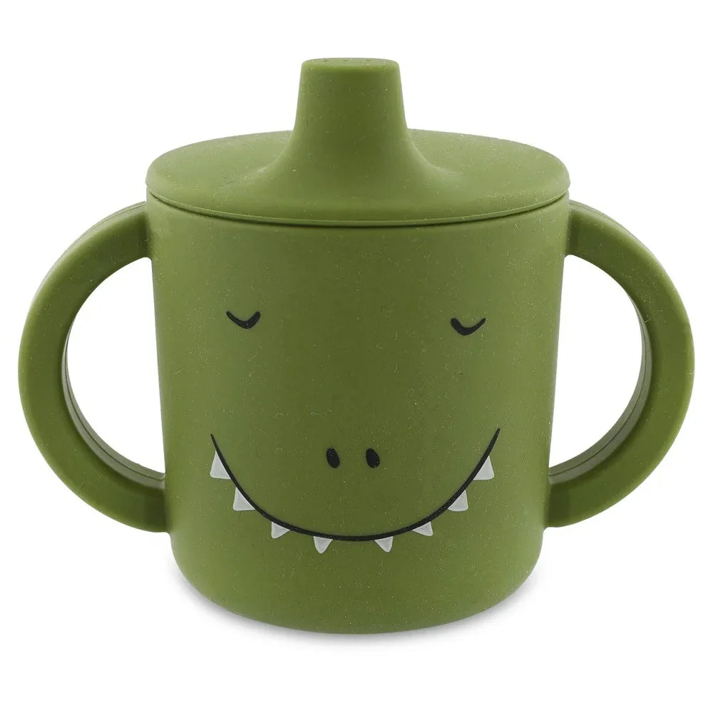Vaso de aprendizaje de silicona verde con dos asas y un simpático diseño de cara de dinosaurio