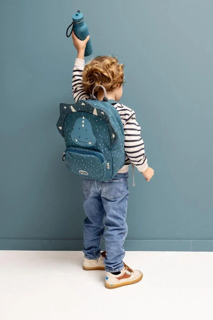 Enfant tenant une gourde en inox bleue et portant un sac à dos dinosaure bleu
