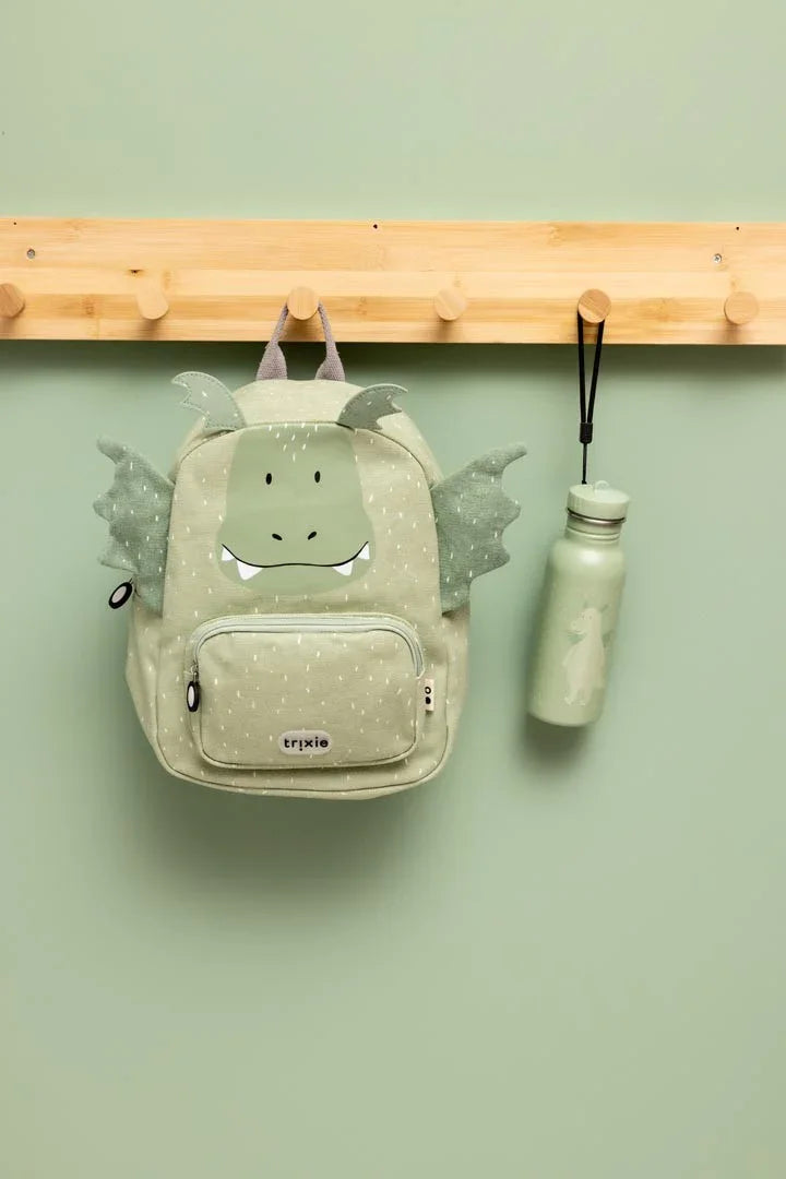 Gourde inox vert clair motif dragon 500ml, suspendue à côté d'un sac à dos assorti sur patère en bois.