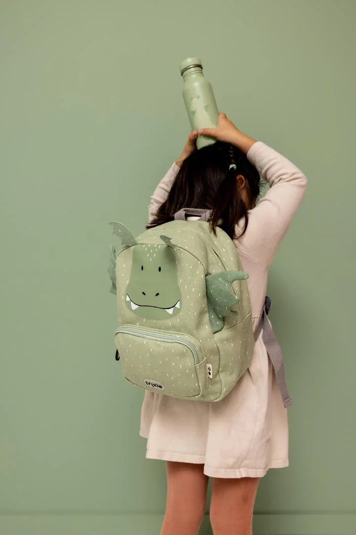 Gourde inox vert pastel avec dragon, tenue par un enfant avec son sac à dos assorti.
