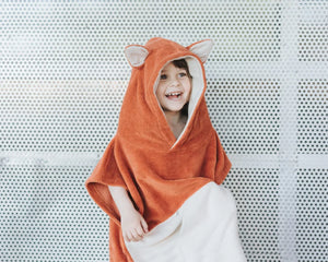 Enfant portant un poncho de bain renard orange avec capuche et oreilles, matière éponge douce