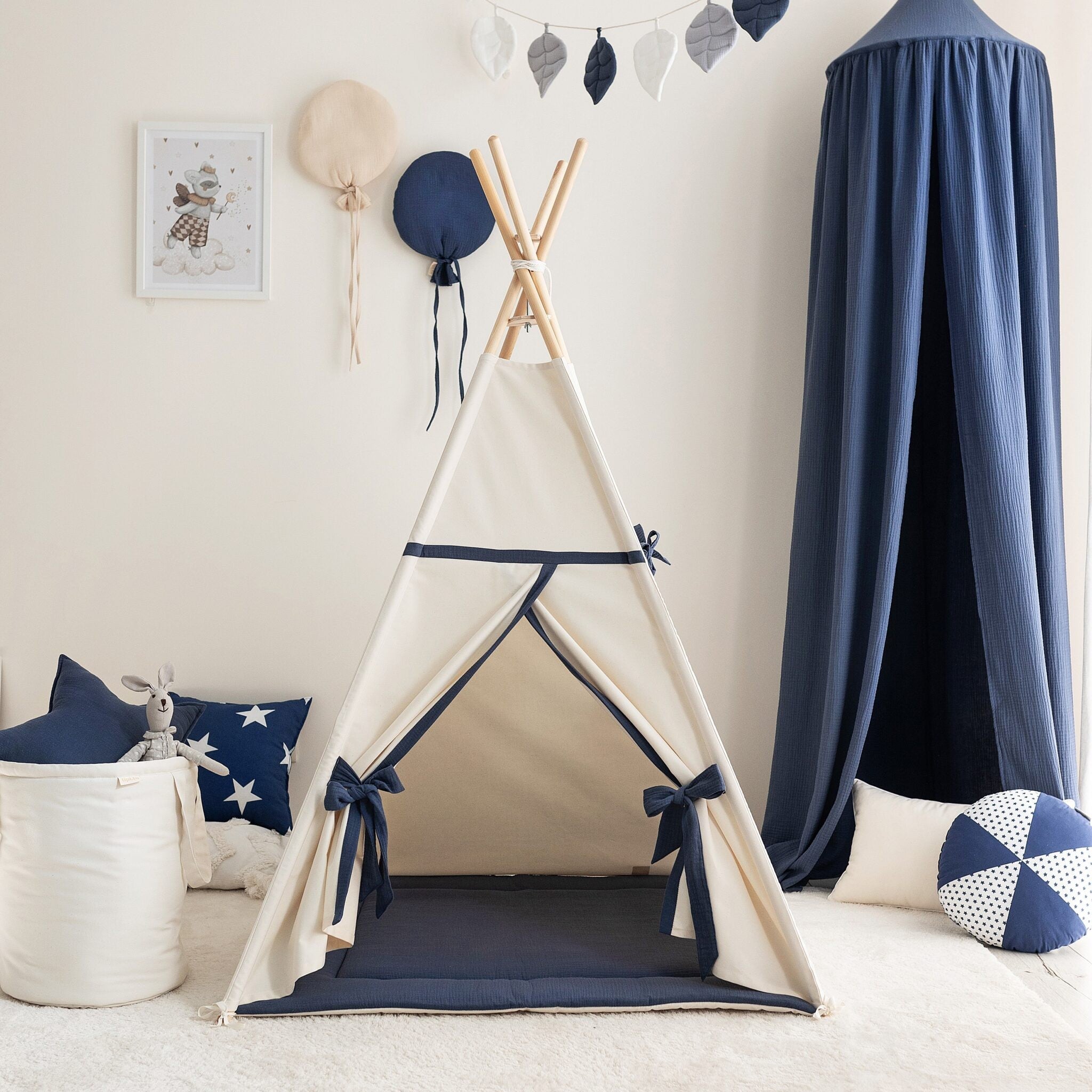 Beige and navy children’s teepee tent with a padded floor mat in a softly styled playroom