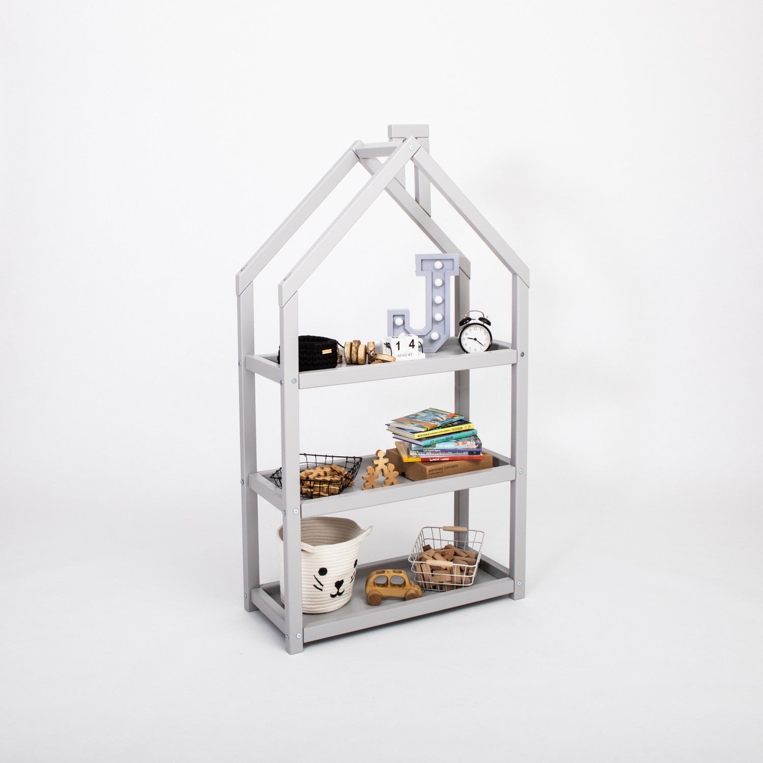 Grey house-shaped kids shelf with books, basket storage, wooden toys and clock on white studio background