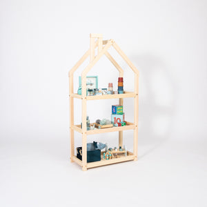 Natural wood house-shaped Montessori shelf with toys, blocks and children’s accessories on three open levels