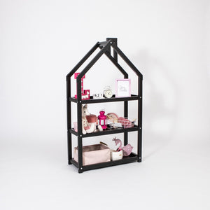 Black house-shaped children’s shelf styled with pink accessories, baskets and decorative objects