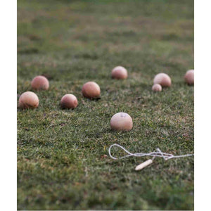 Handcrafted wooden bocce balls on grass, natural finish, outdoor garden game set