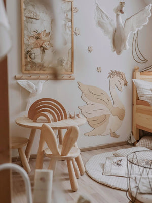 Decorazione da parete in legno a forma di cigno con corona floreale in una nursery naturale, arredamento in legno chiaro