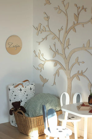 Décoration murale arbre en bois avec oiseaux dans un coin de chambre bébé minimaliste, déco neutre